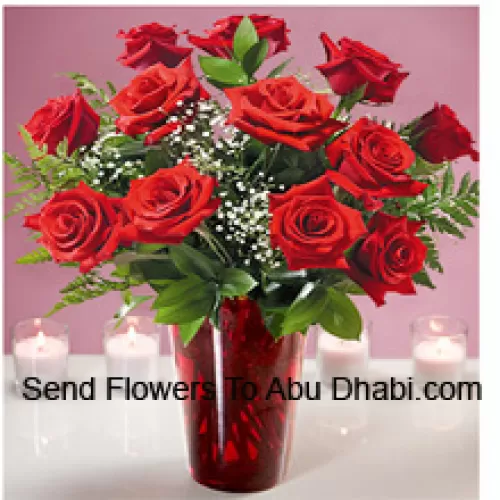 12 Red Roses With Some Ferns In A Glass Vase